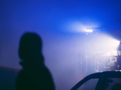 Silhouette of a person stretching against a dark background.