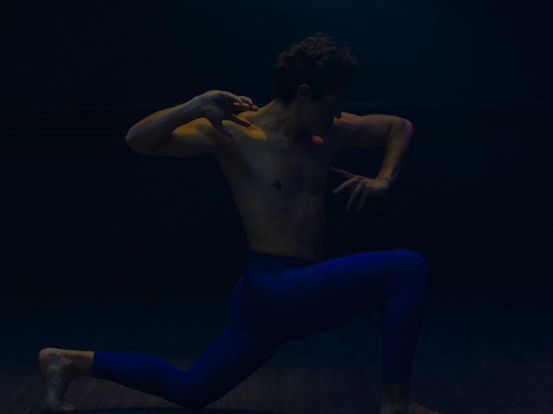 Wide view of a modern dark yoga studio with neon accents.